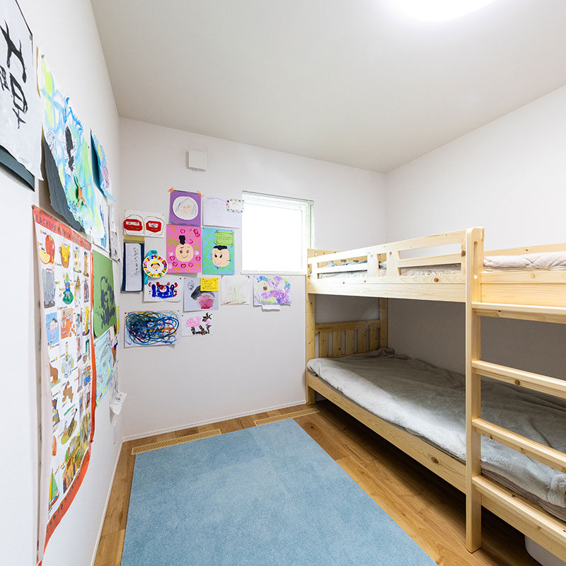 子ども部屋は２つあるが、お子様が小さい今は一つの部屋で過ごし、もう一つの部屋は収納スペースとして活用している。白い壁はお子様たちの書画や工作の展示コーナーに。寝室や書斎兼仕事部屋も含めて個室は成長にあわせてフレキシブルに活用していく予定。